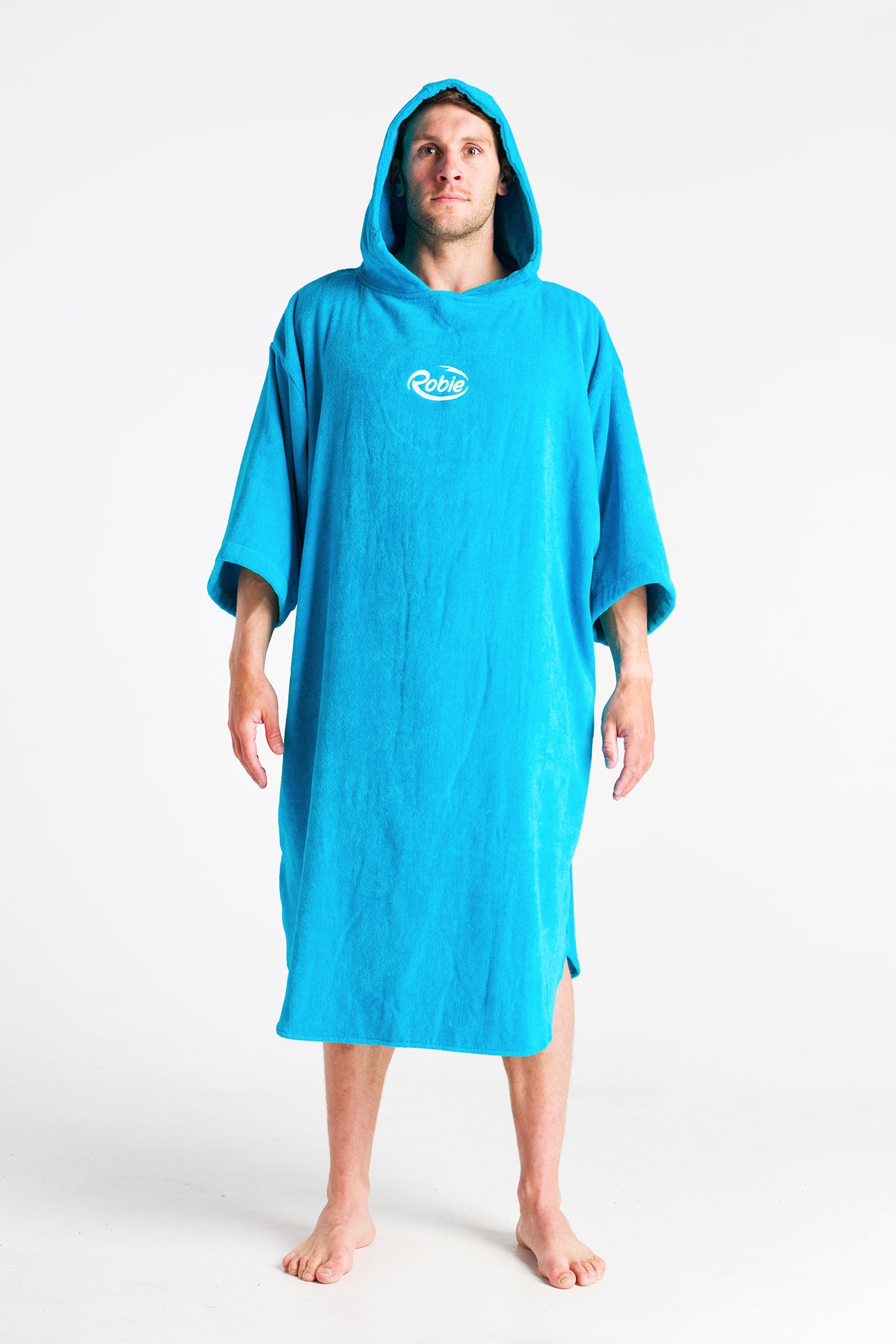 A person stands barefoot on a white background, wearing a bright blue Robie Long Sleeve Towel Robe featuring the "Robie" logo on the chest.