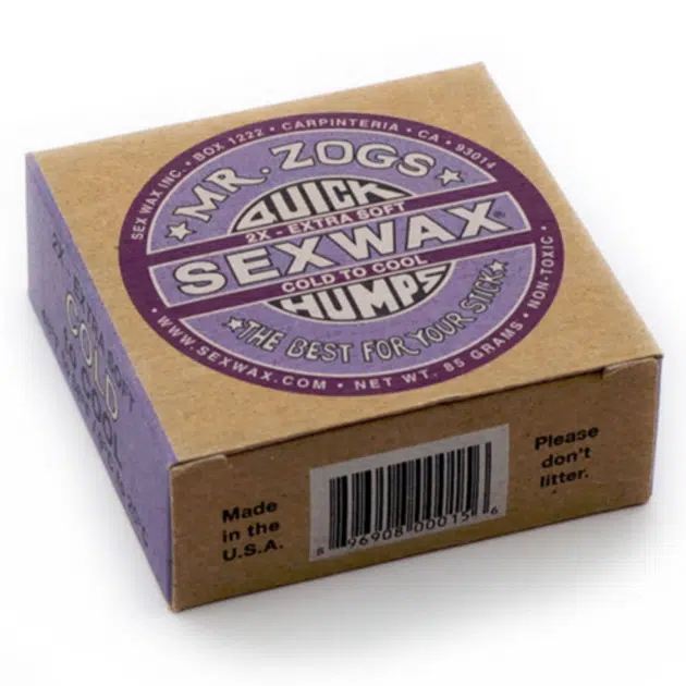 A box of Sex Wax Quick Humps Cold Water Surf Wax, labelled "2X Extra Soft" and "Cold to Cool," featuring purple and white graphics on brown cardboard. The package also says, "Please don't litter.