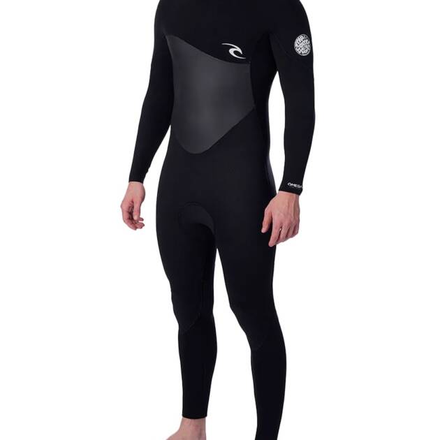 A person stands barefoot against a white background wearing the Rip Curl Men's Omega 5/3mm Back Zip Wetsuit, a full-length black wetsuit with long sleeves, chest panel, and logo details on the chest and left arm.